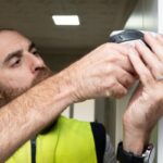 young-man-fixing-door-with-screwdrive
